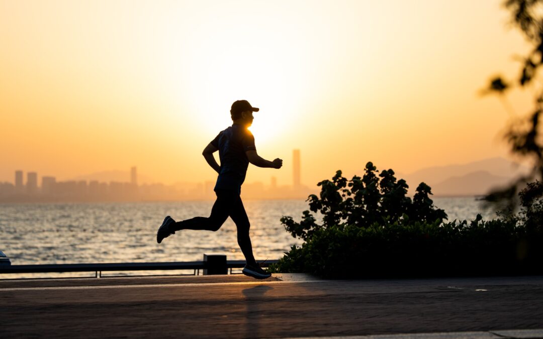 a man running on the beach at sunset